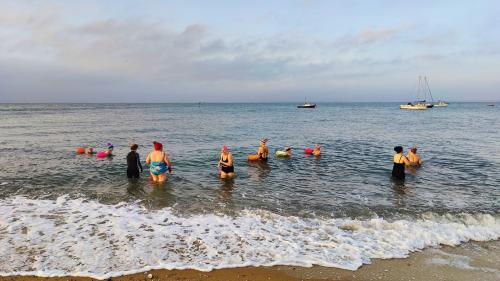 Group of people swimming in the sea at Southend as part of YogaSwim