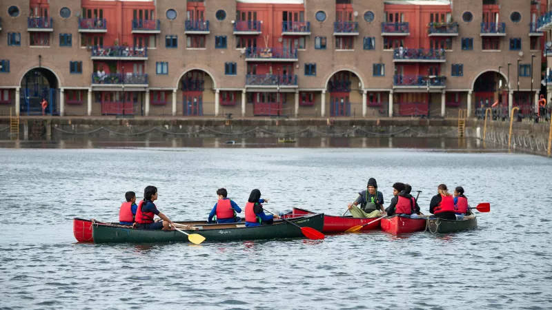 Children in canoes at Shadwell Basin River Thames